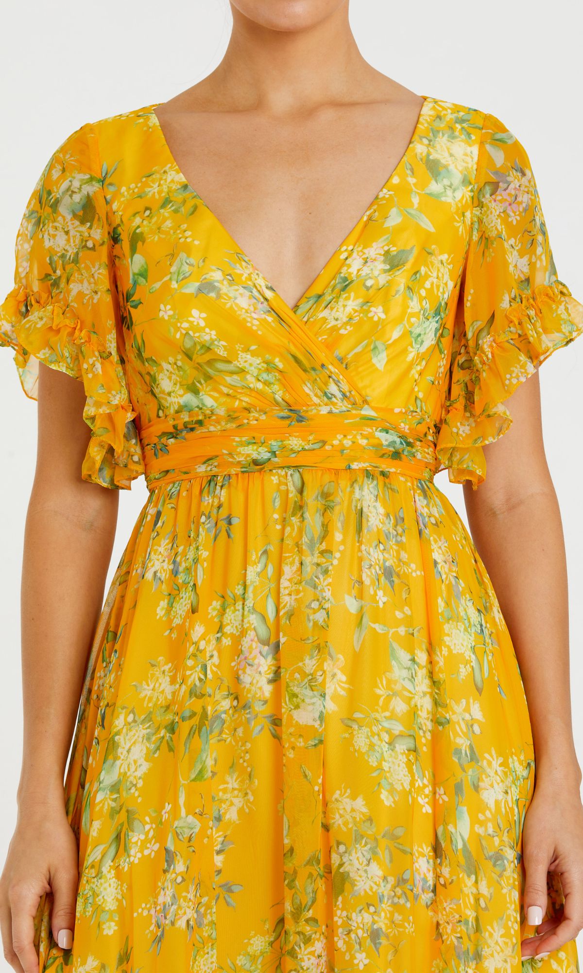 A woman wearing the Floral-Print Long Formal Dress 70241 by Mac Duggal, featuring a yellow Bohemian floral print, short ruffled sleeves, V-neckline, and fitted waist.